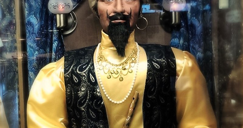 Der Wahrsage-Automat „Zoltar“ hinter Glas: eine Puppe mit Turban, Goldjacke und schwarzem Bart, die Hand über einer leuchtenden Kristallkugel.